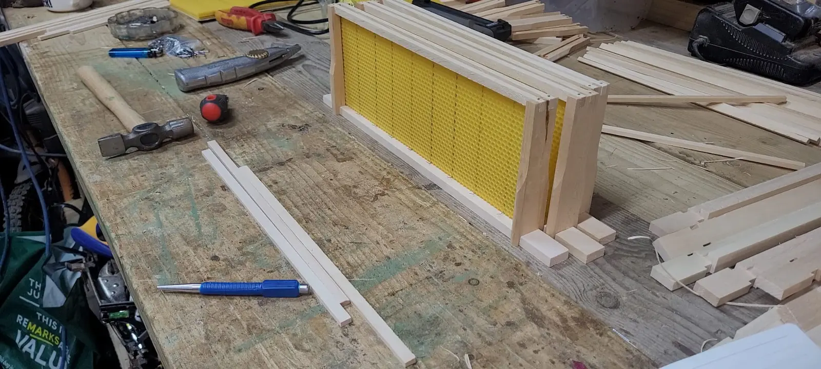 Beekeeper assembling wooden brood frames as part of winter hive preparation